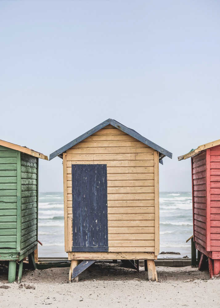 Beach huts poster with colorful beach huts on a sandy beach by the ocean