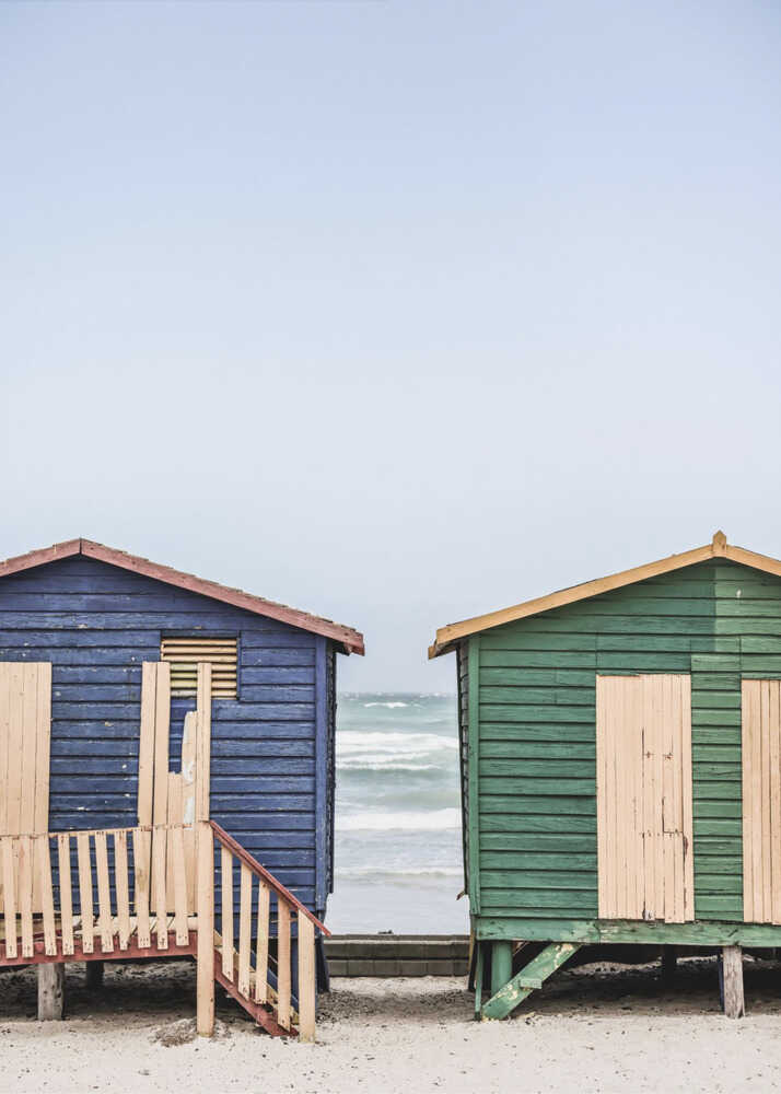 Blue green beach huts poster with blue and green beach huts on a sandy beach