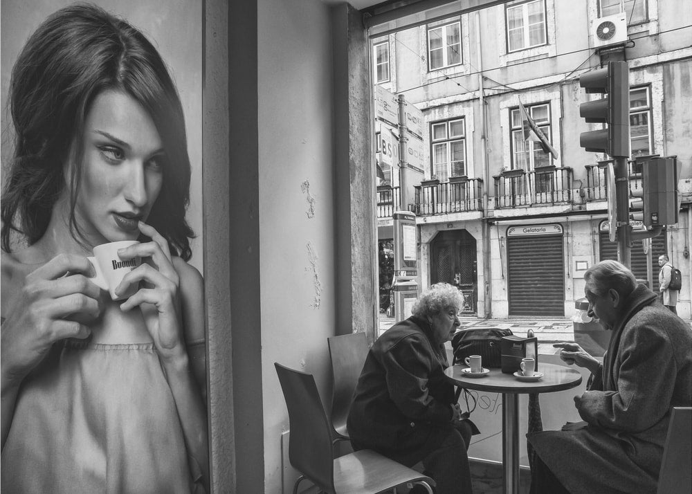 Cafe scene black and white poster with a mural of a woman drinking coffee and people at a table