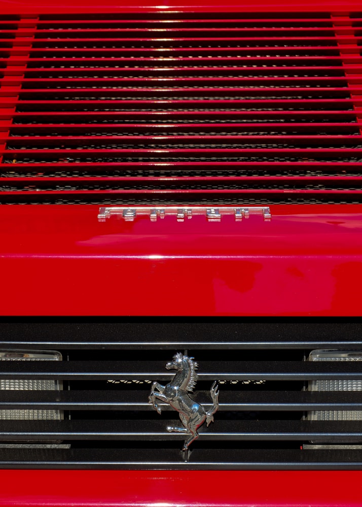 Ferrari grille poster with a close-up of a red Ferrari grille and prancing horse logo
