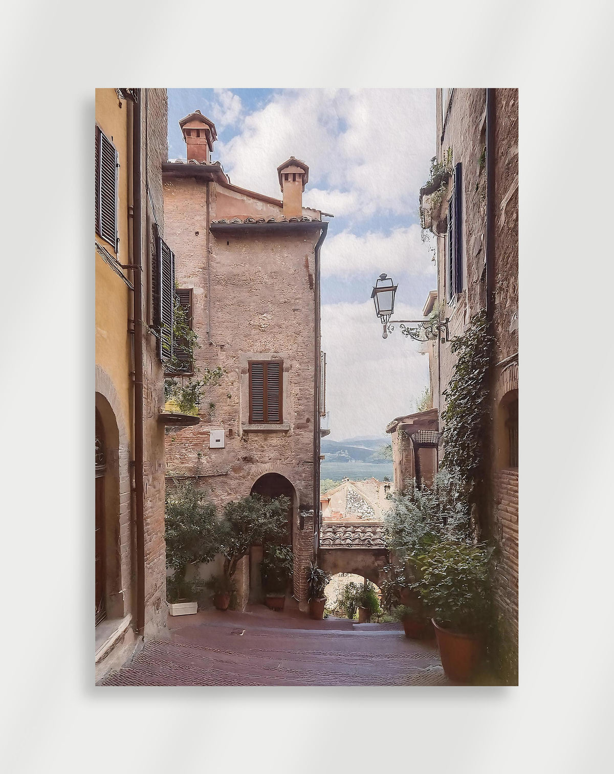 Italian alley view poster with a narrow cobblestone street in an Italian hill town with a lake view