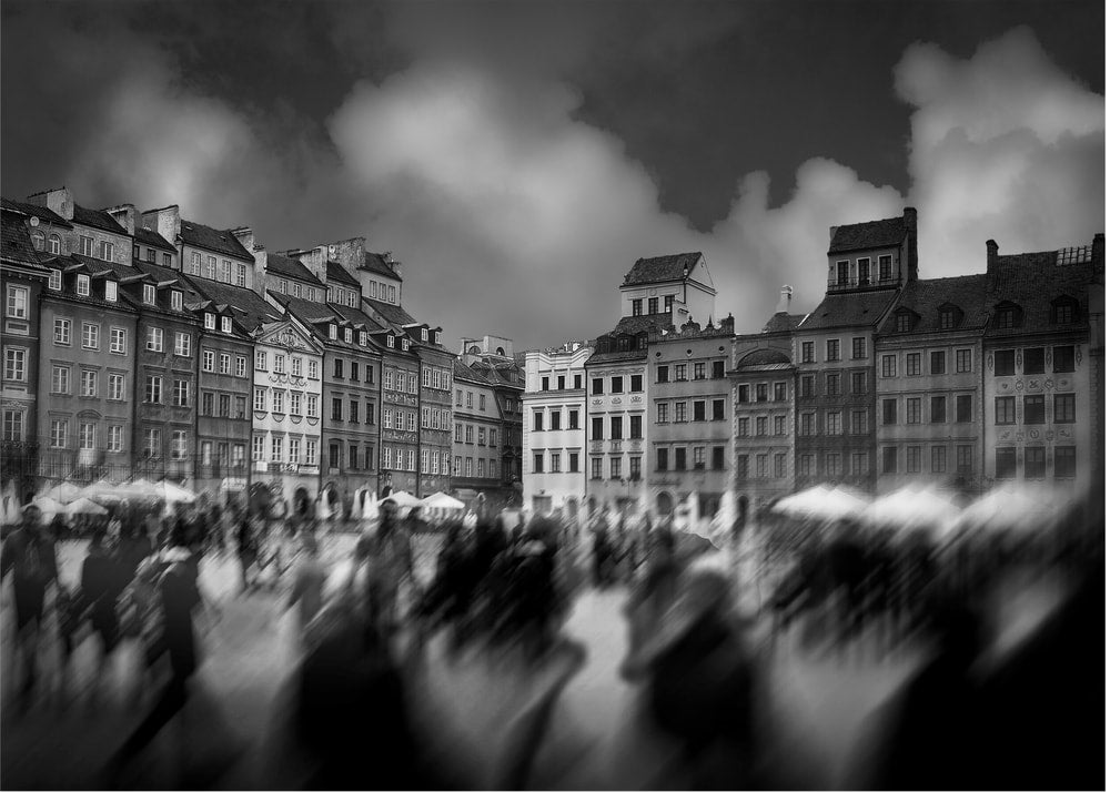 Old town square poster with a black and white view of historic buildings and blurred people
