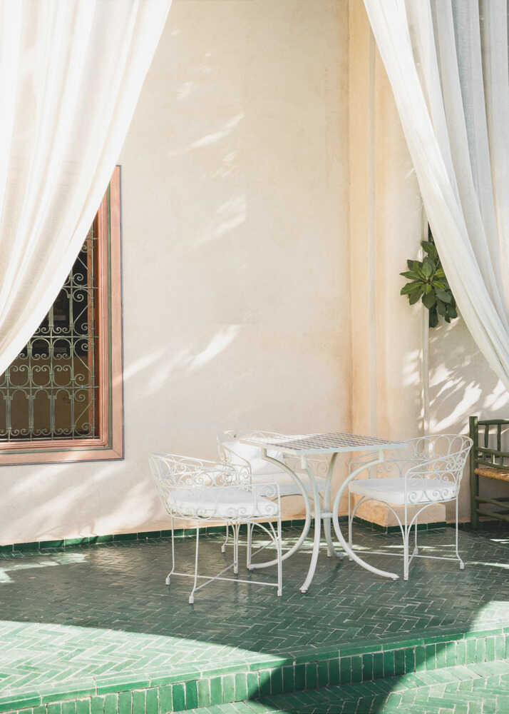 Sunny terrace poster with white metal chairs and table on a green tiled floor with white curtains