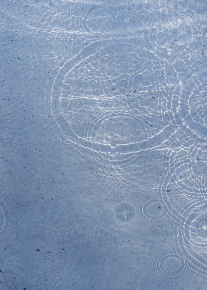Water ripples poster with a close-up of water surface with ripples and light reflections