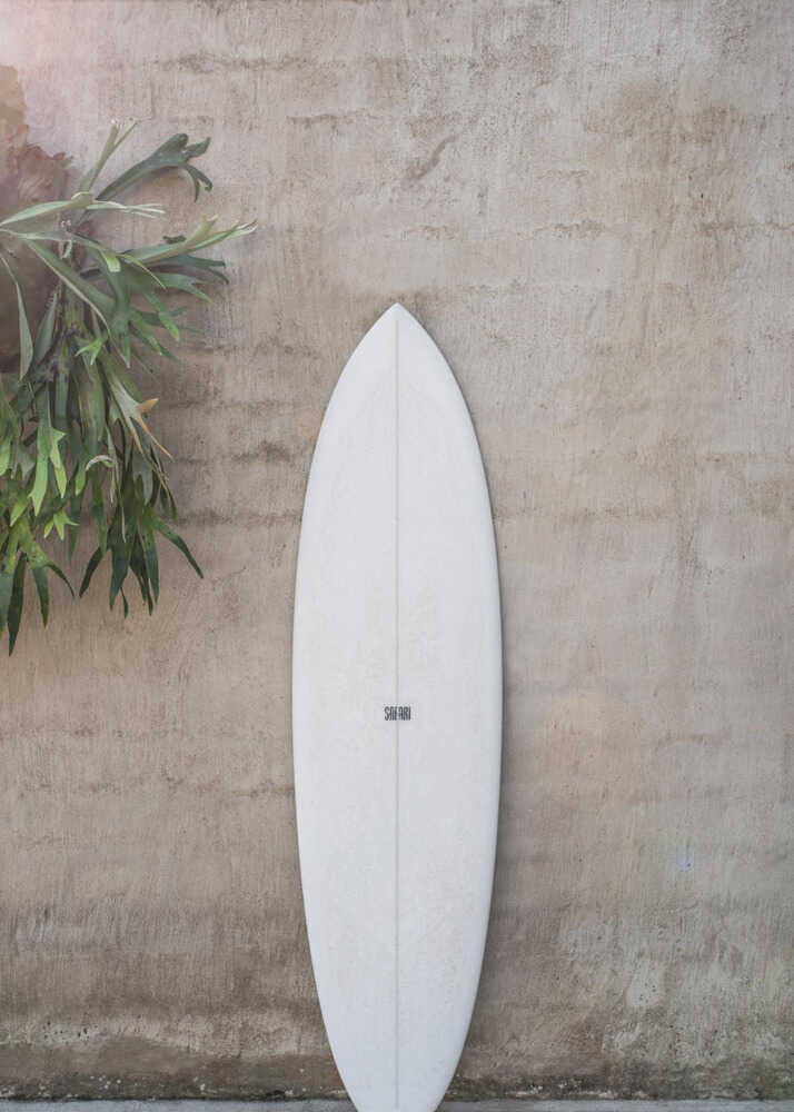 White surfboard poster with a white surfboard leaning against a concrete wall