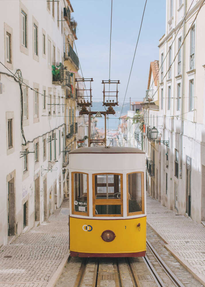 Yellow tram poster with a yellow and white tram on a narrow cobblestone street